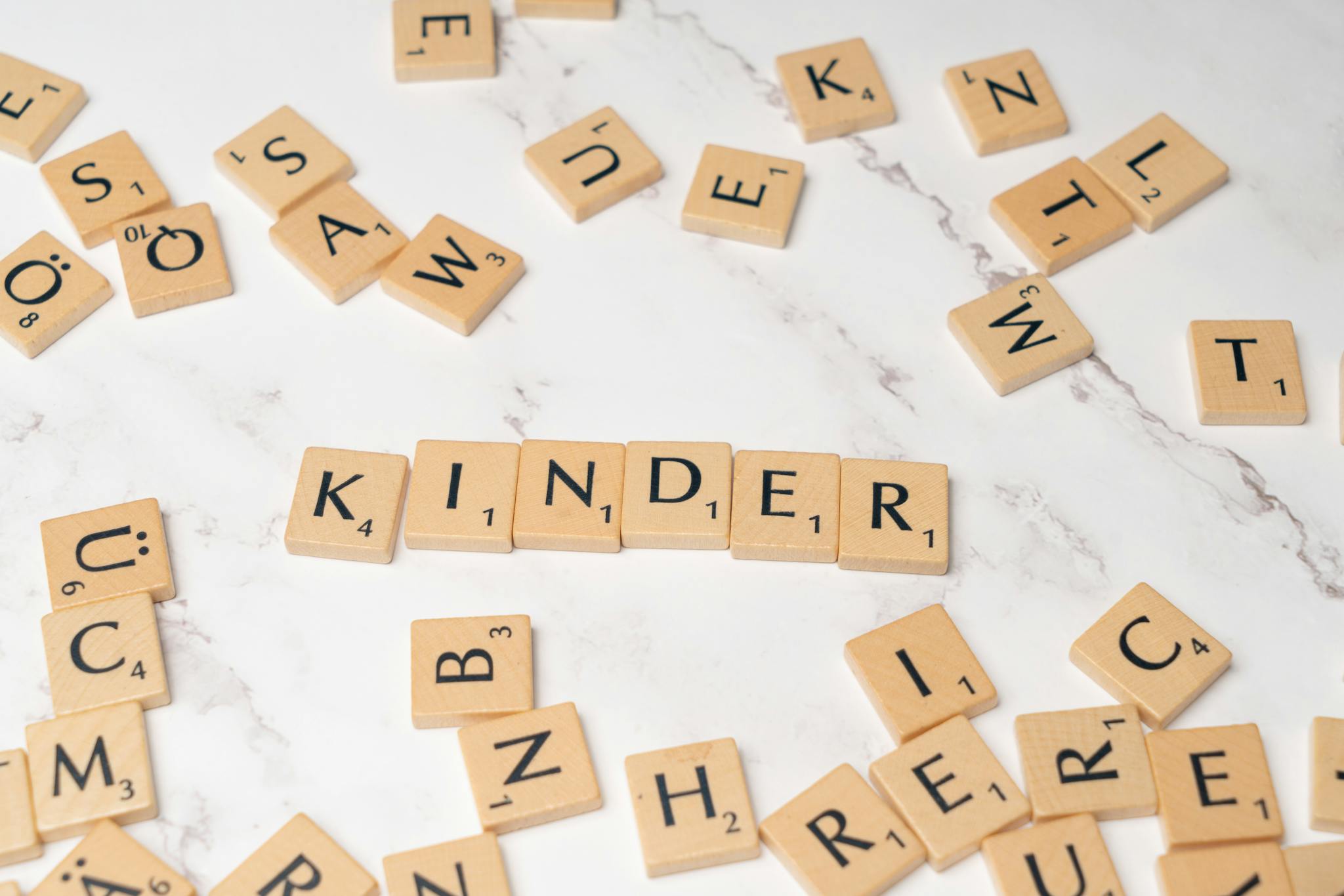 Scrabble letters spelling the word kinder